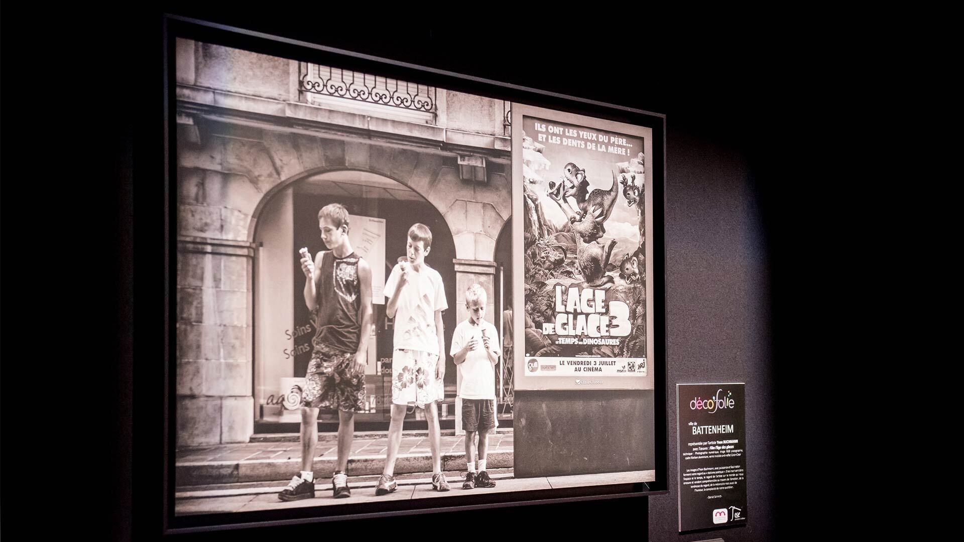 Foire de Mulhouse 2023 - m2Art Déco'Folie - Photo en noir et blanc d'une affiche l'Age de Glace 3 avec 3 enfants qui savourent une glace à côté