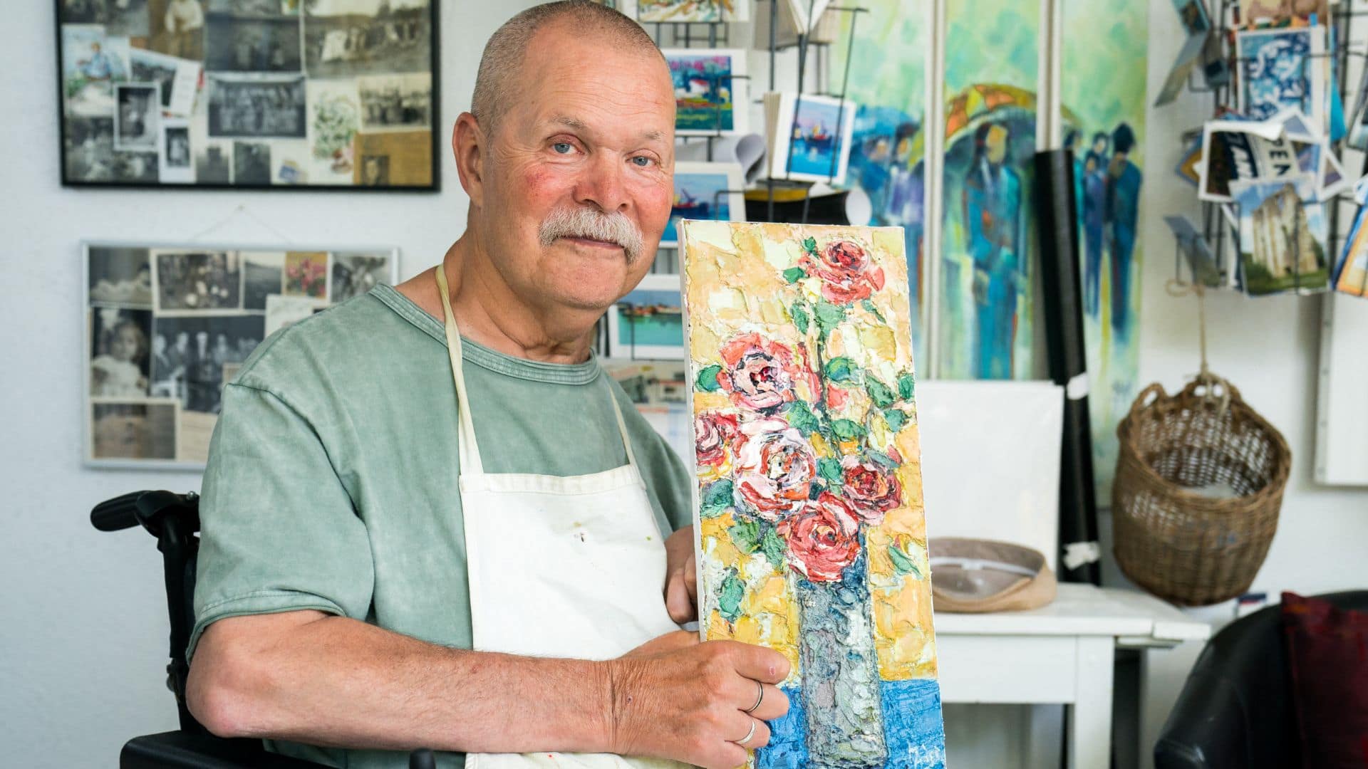 Christian Maeder avec son tableau représentant un vase de roses