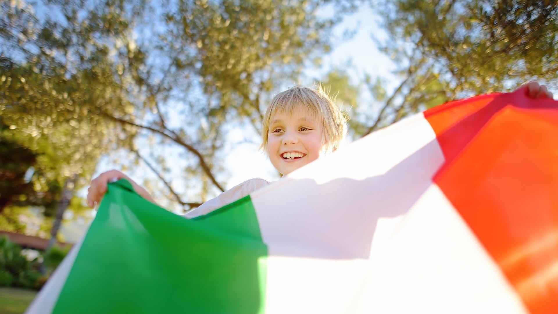 enfant qui porte avec fierté un drapeau de l'Italie