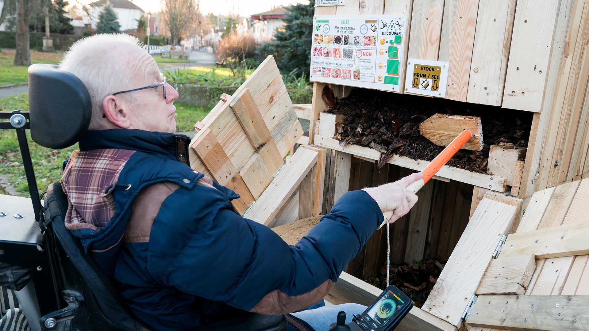 Homme en situation de handicap qui utilise le composteur inclusif