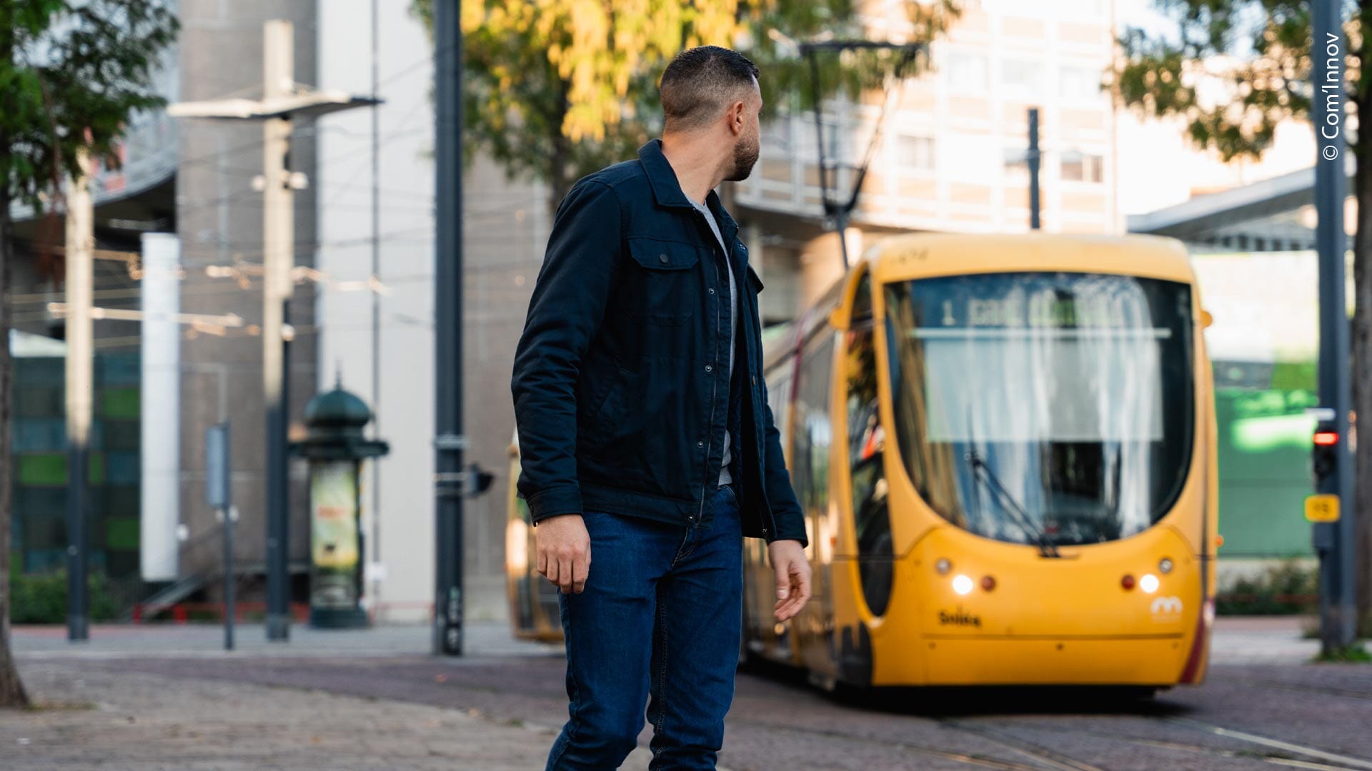 Homme qui regarde avant de traverser les voies du tramway