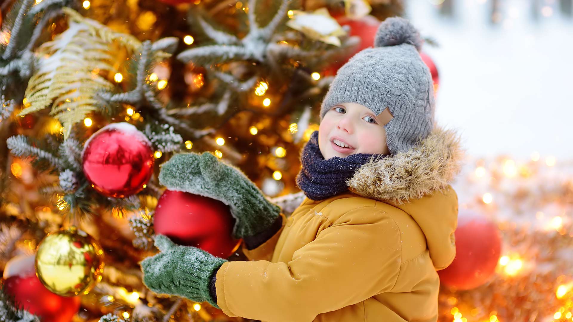 Enfant devant un sapin de Noël